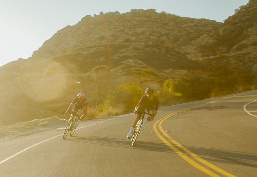 Cyclistes à l'entraînement sur une route de montagne en fin de journée