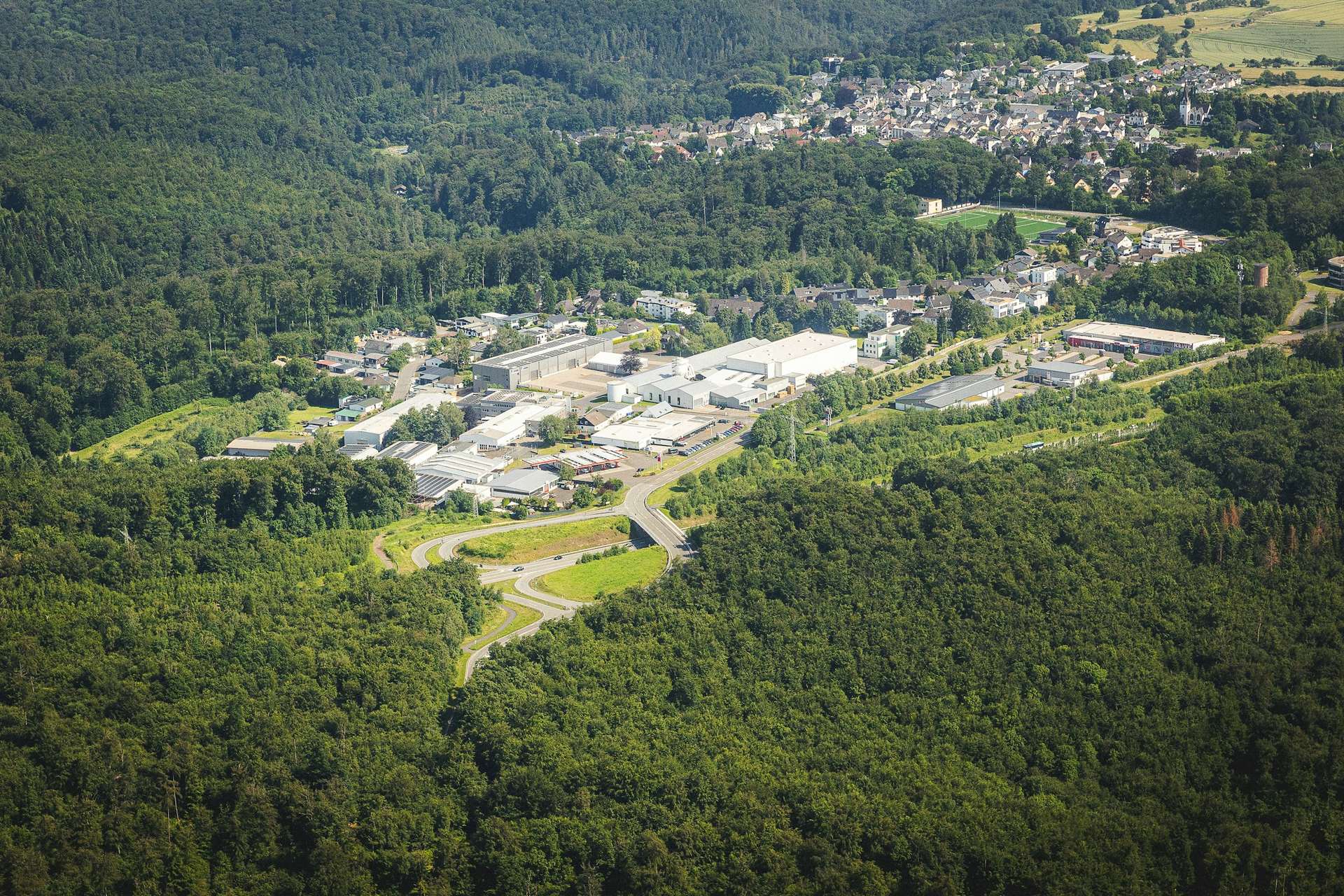 Parc d'activités économiques vu du ciel, entouré de forêt