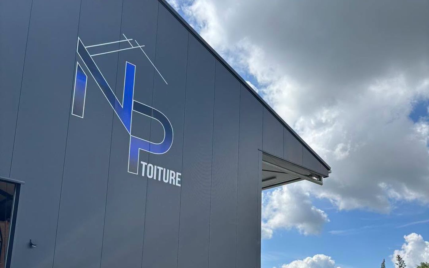 Hall de NP Toiture à Bastogne, enseigne sur le bardage et nacelle élévatrice
